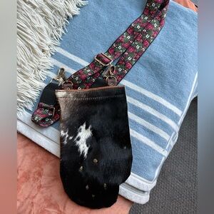 Locally crafted maximalist satchel with cow hide and floral adjustable straps.